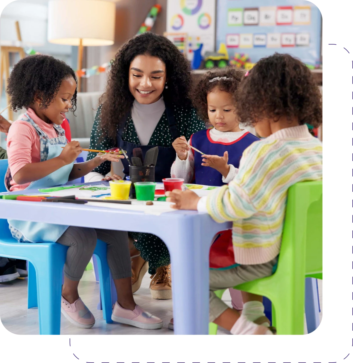 Children painting with teacher at preschool